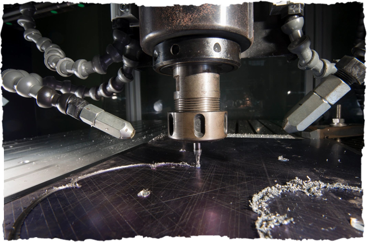 A machine is cutting the metal with a large drill.